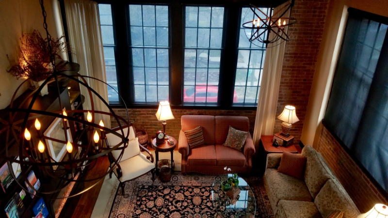 Photo of the same living room with furniture, decor, and lighting